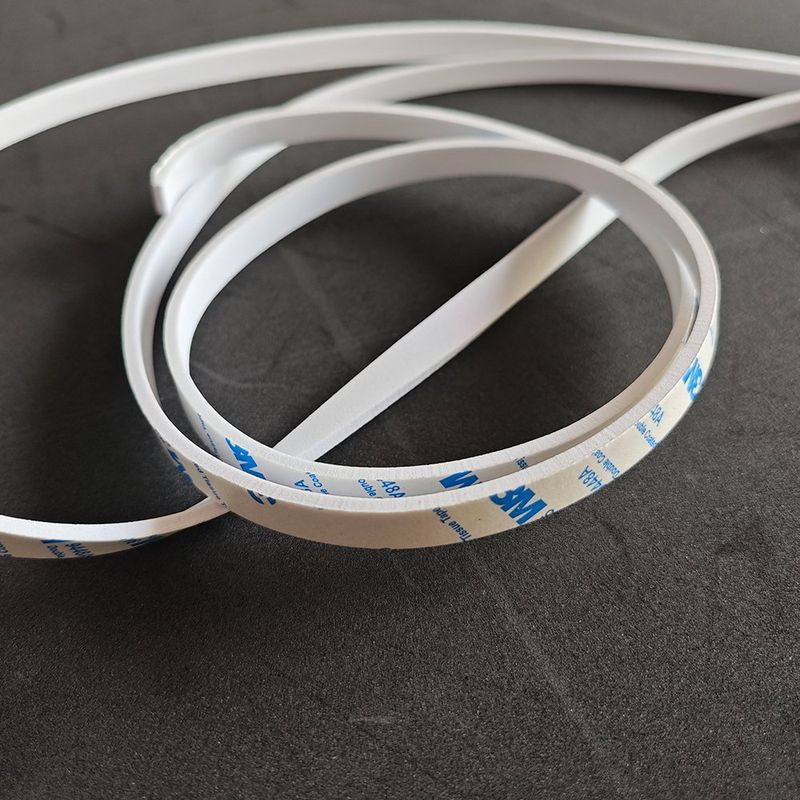 Close-up of white EVA self-adhesive strip curling (3M backing)